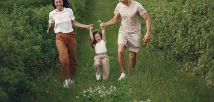 Joyful family enjoying a fun day outdoors in a green field, epitomizing togetherness and happiness.